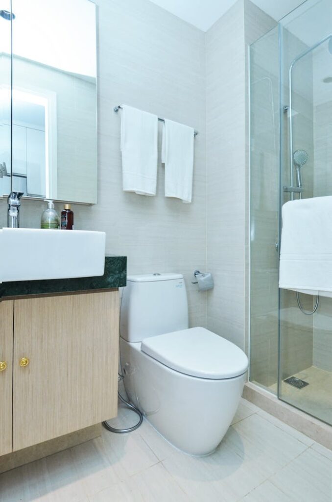 Modern bathroom with a toilet, sink, and shower, representing plumbing repair services